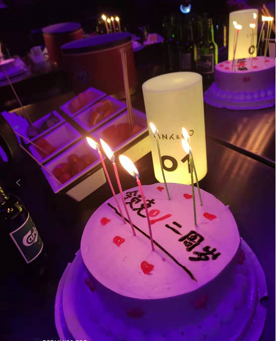 全场所有人点亮自己桌上蛋糕的蜡烛,一起吹灭许愿的场景,在躁动的酒吧